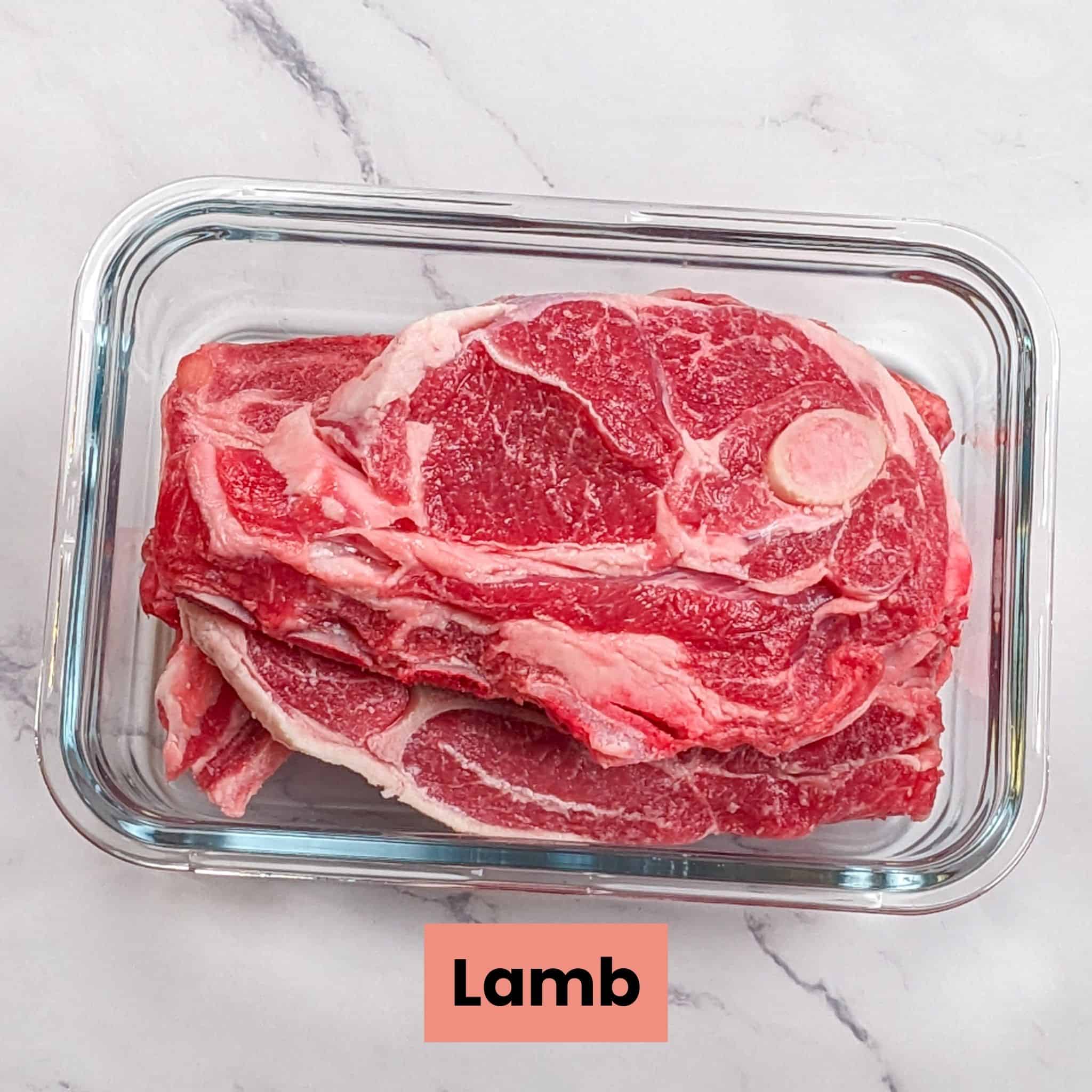 lamb steak chops in a rectangle glass container for the Quick and Easy Lean Baharat Spiced Bean and Lamb Stew recipe