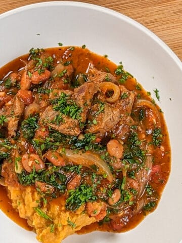 top view of the Baharat Spiced Bean and Lamb Stew served with sweet mashed potatoes in a wide rim bowl