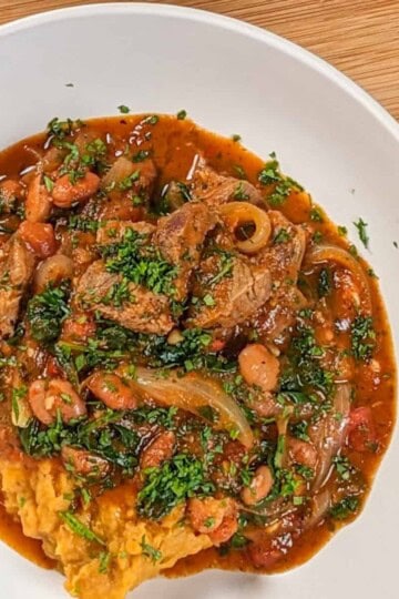 top view of the Baharat Spiced Bean and Lamb Stew served with sweet mashed potatoes in a wide rim bowl