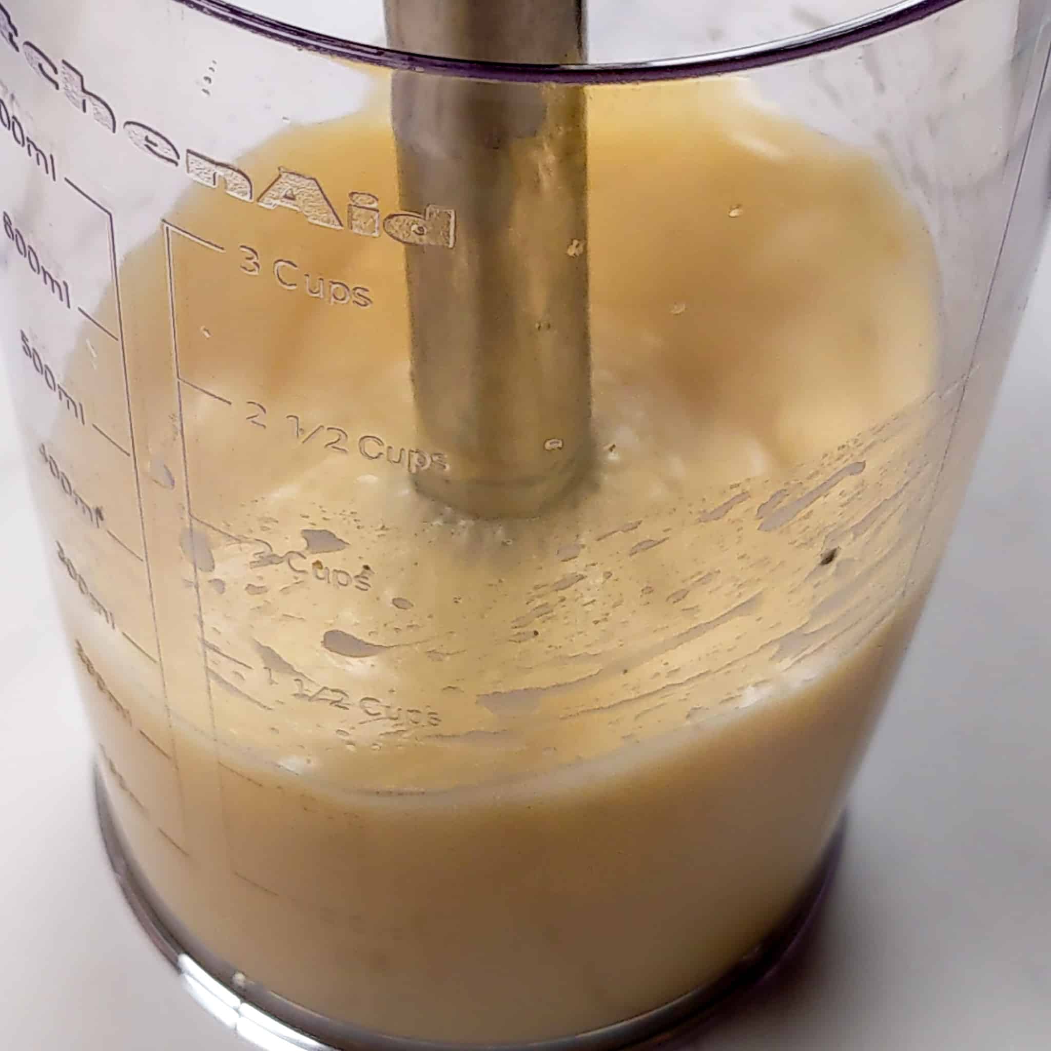 close up shot of blending the citrus vinaigrette using the KitchenAid Cordless Variable Speed Hand Blender in the KitchenAid blending jar