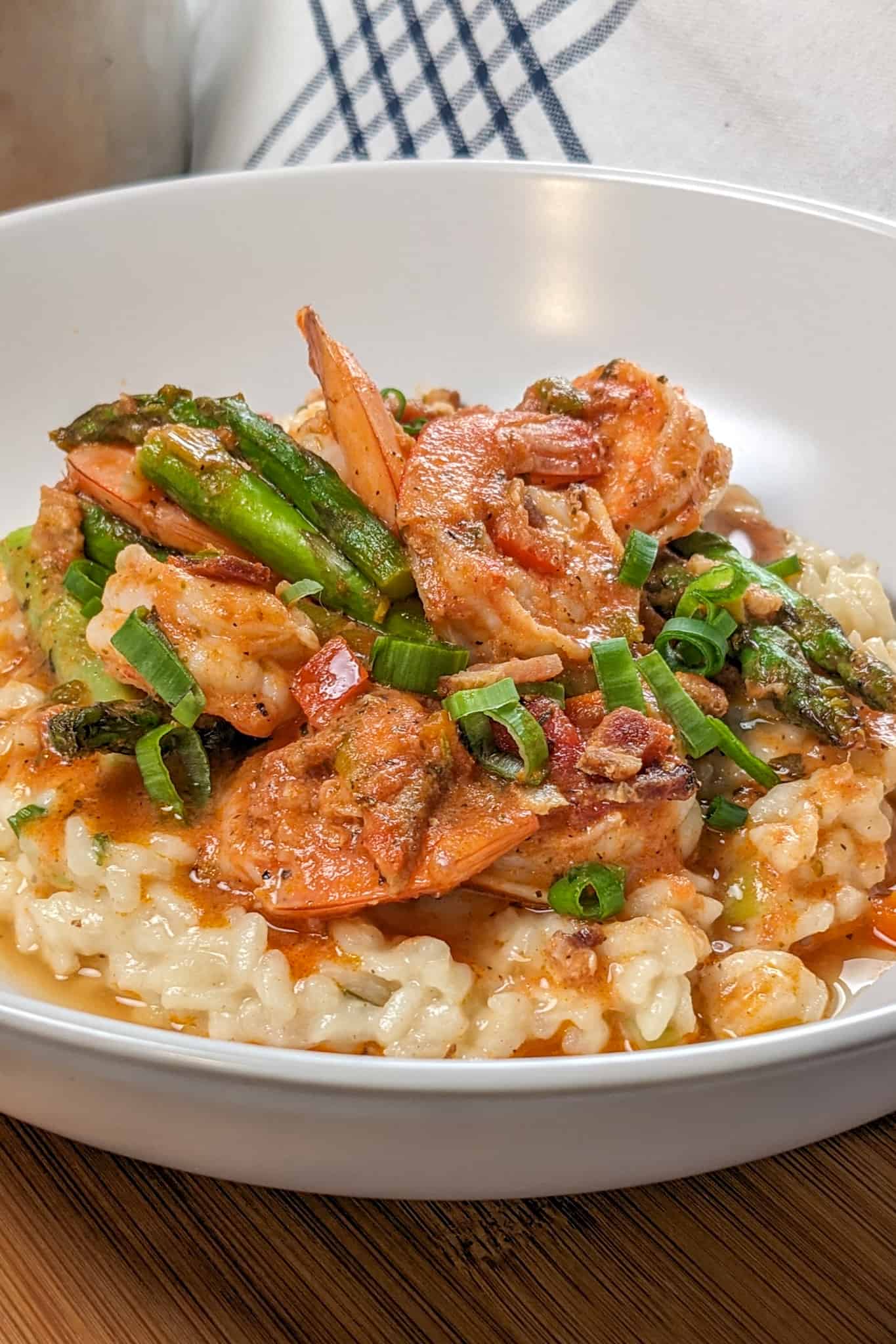 Side view of the Spicy Creole Shrimp and White Cheddar Cheese Risotto in a wide rim bowl.