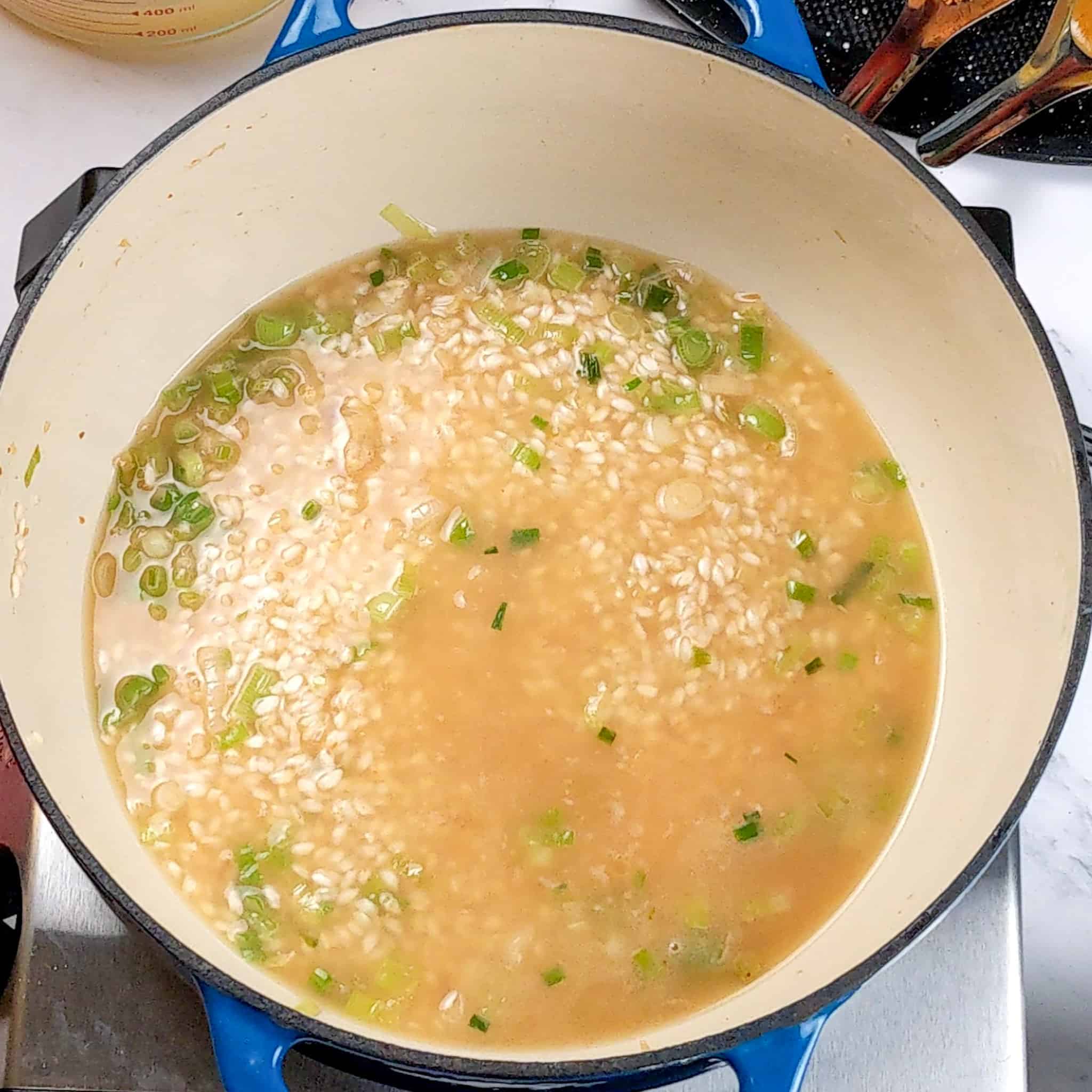 rice with aromatics covered with chicken broth