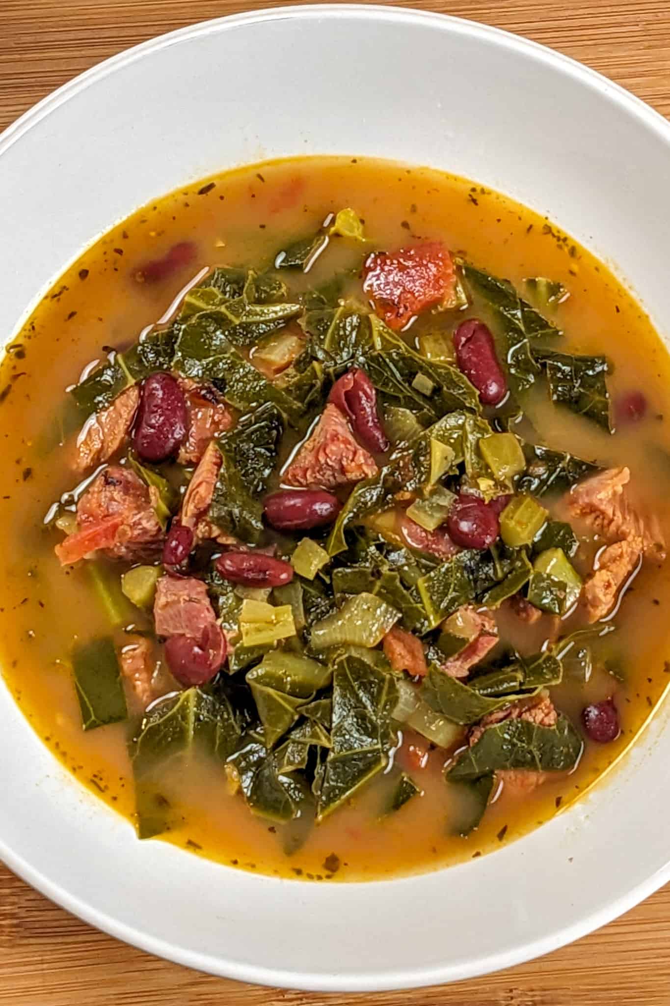 Top view of the Scotch Bonnet Smoked Turkey Collard Greens Beans Soup in a wide rim bowl