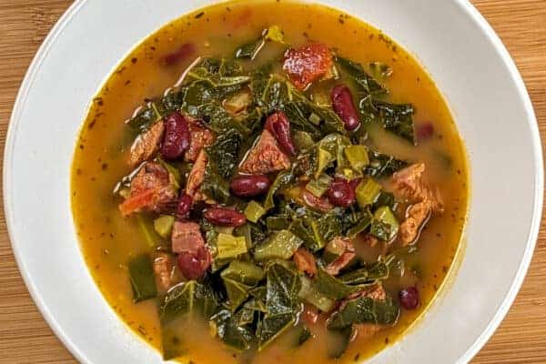 Top view of the Scotch Bonnet Smoked Turkey Collard Greens Beans Soup in a wide rim bowl