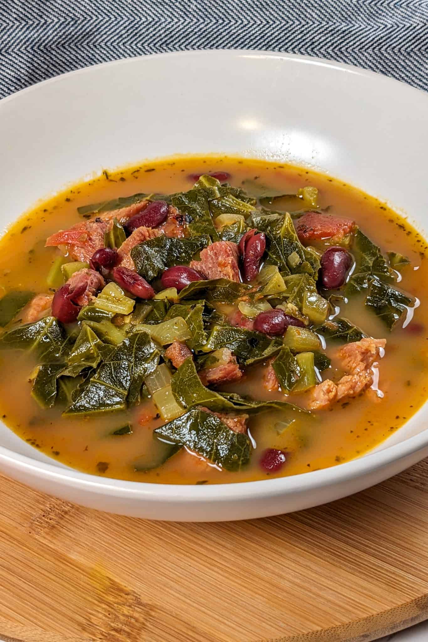 side view of the Scotch Bonnet Smoked Turkey Collard Greens Beans Soup in a wide rim bowl
