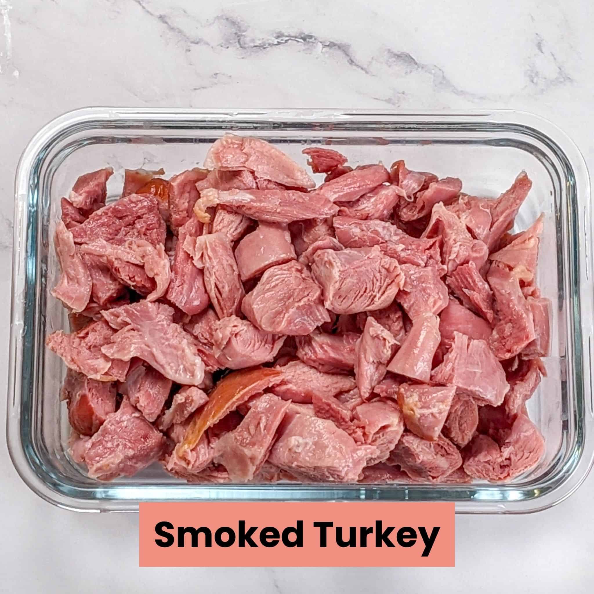 smoked turkey leg meat in small chunks in a glass rectangle container
