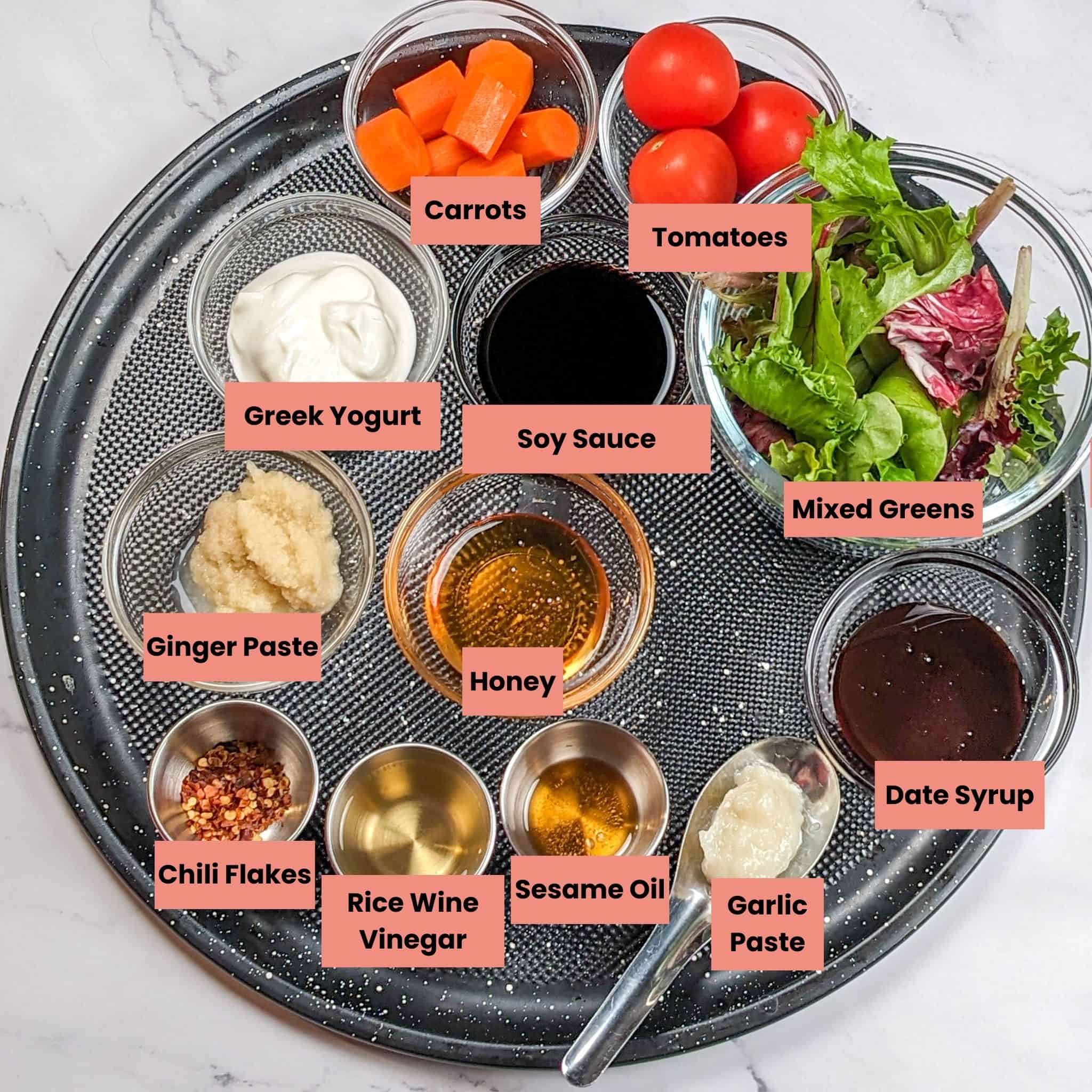 labeled ingredients for the Easy Air Fryer Sticky Date Teriyaki Chicken Wings recipe in containers on a large round pizza pan