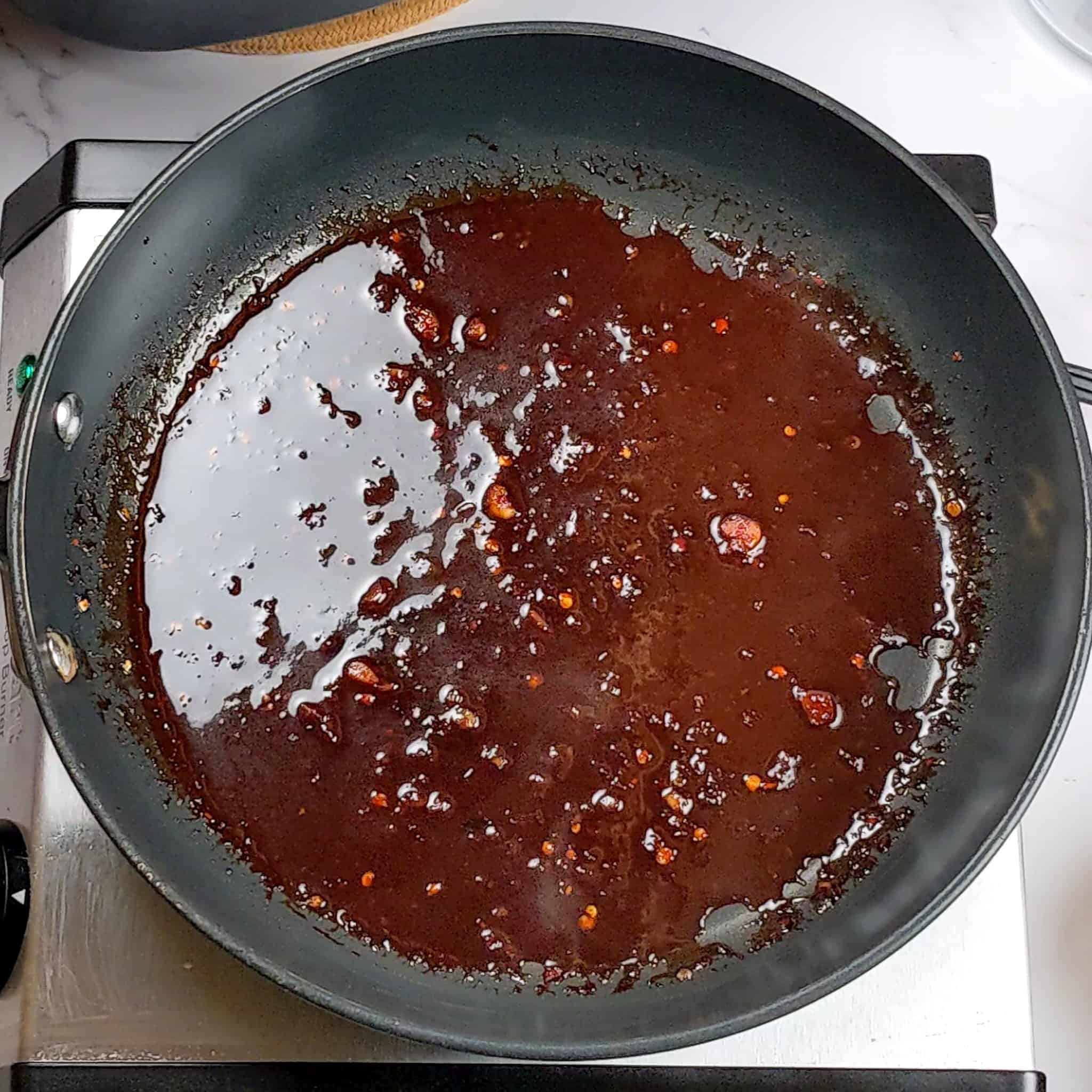 reduced sticky date teriyaki sauce in a non-stick all clad frying pan