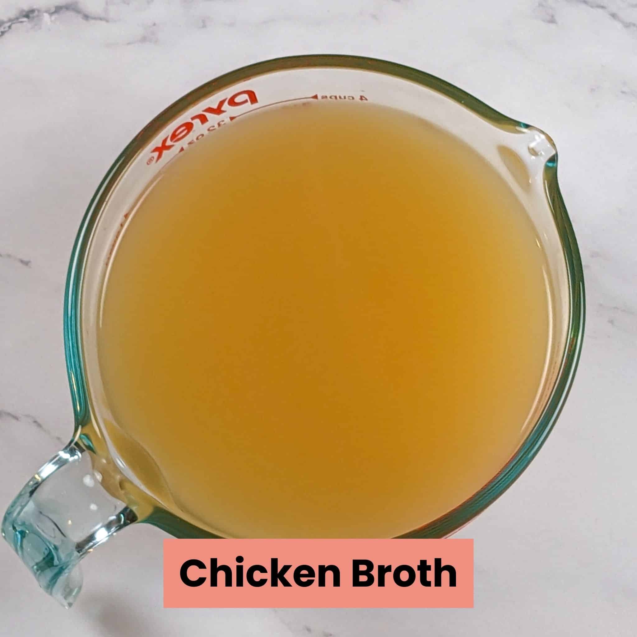 chicken broth in a pyrex glass measuring cup for liquids