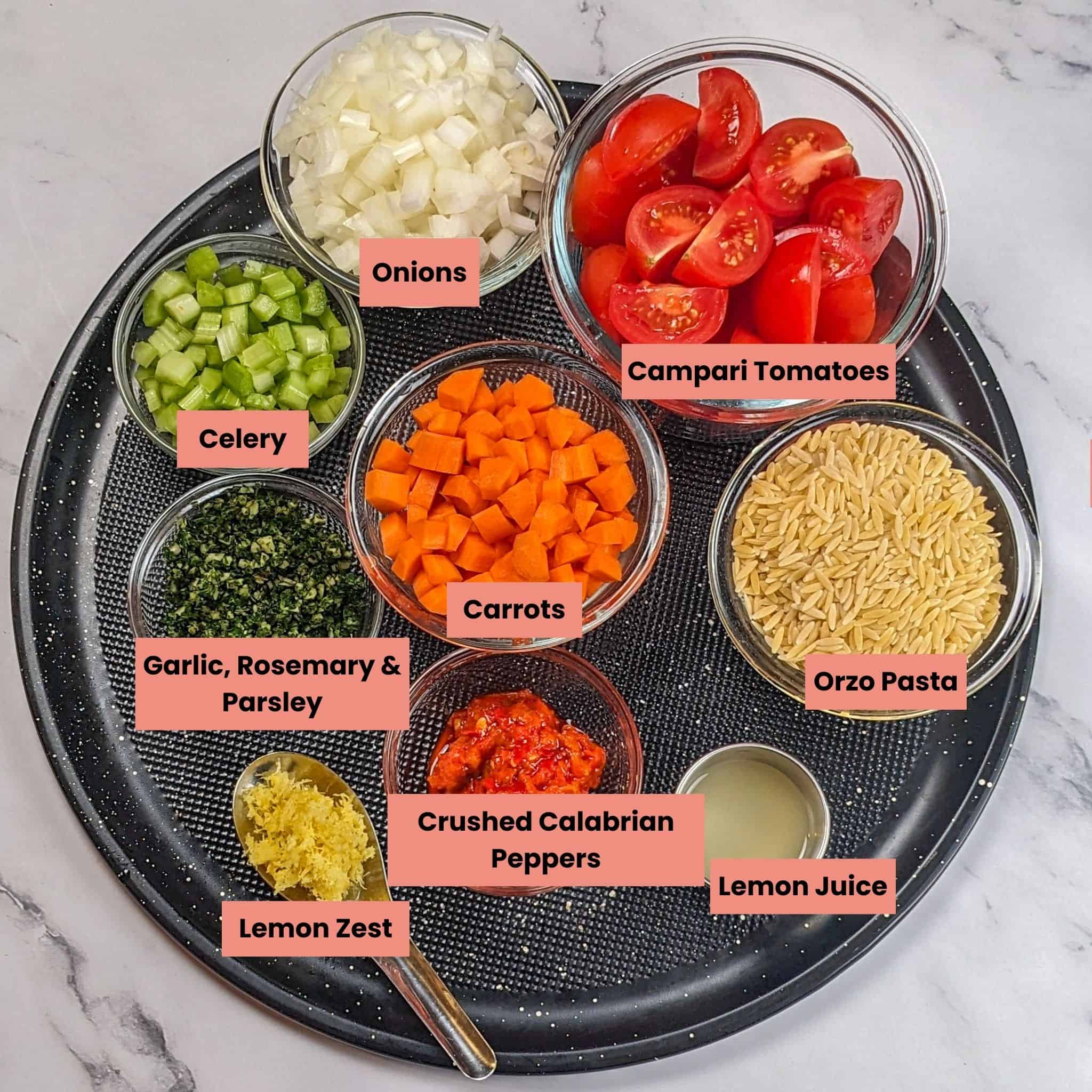 ingredients for the Easy Spicy Lemon Calabrian Chili Chicken Orzo Soup in glass containers on a large round pizza pan.
