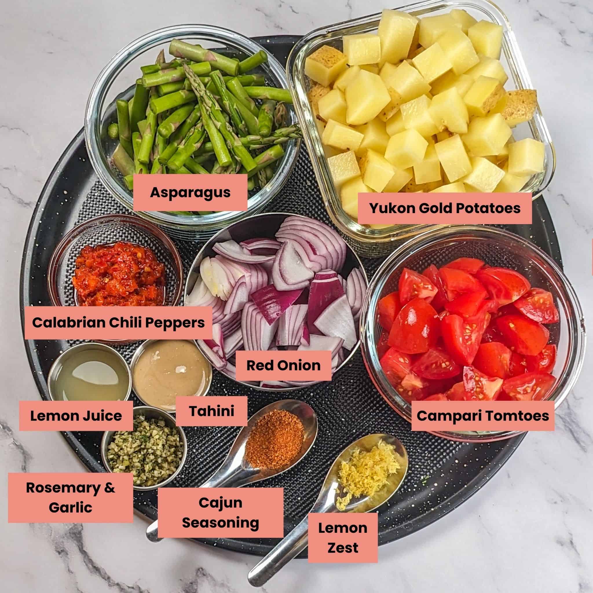 ingredients for the Calabrian salmon vegetable bowl in containers on a large round pizza pan