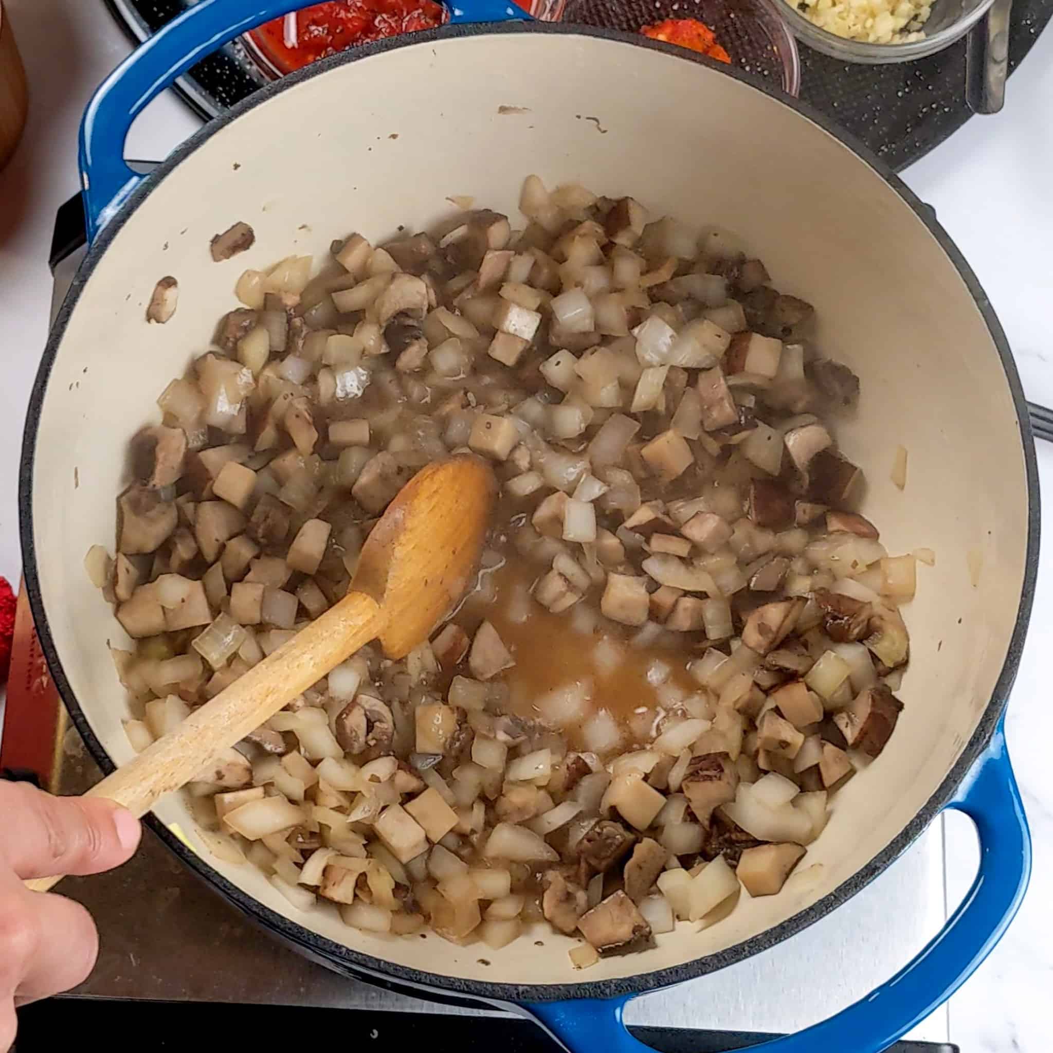 diced portobello mushrooms and onions sweating in a dutch oven