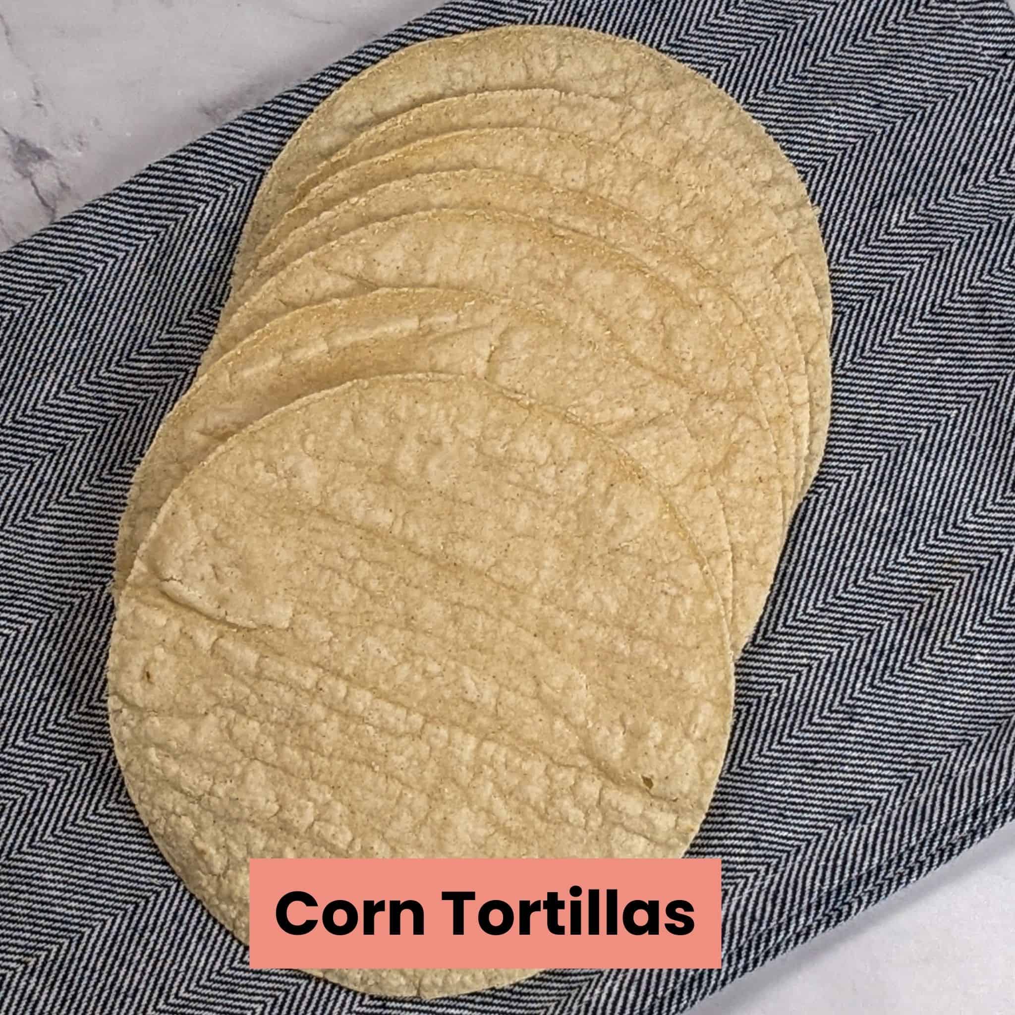 corn tortillas cascading on a kitchen towel.