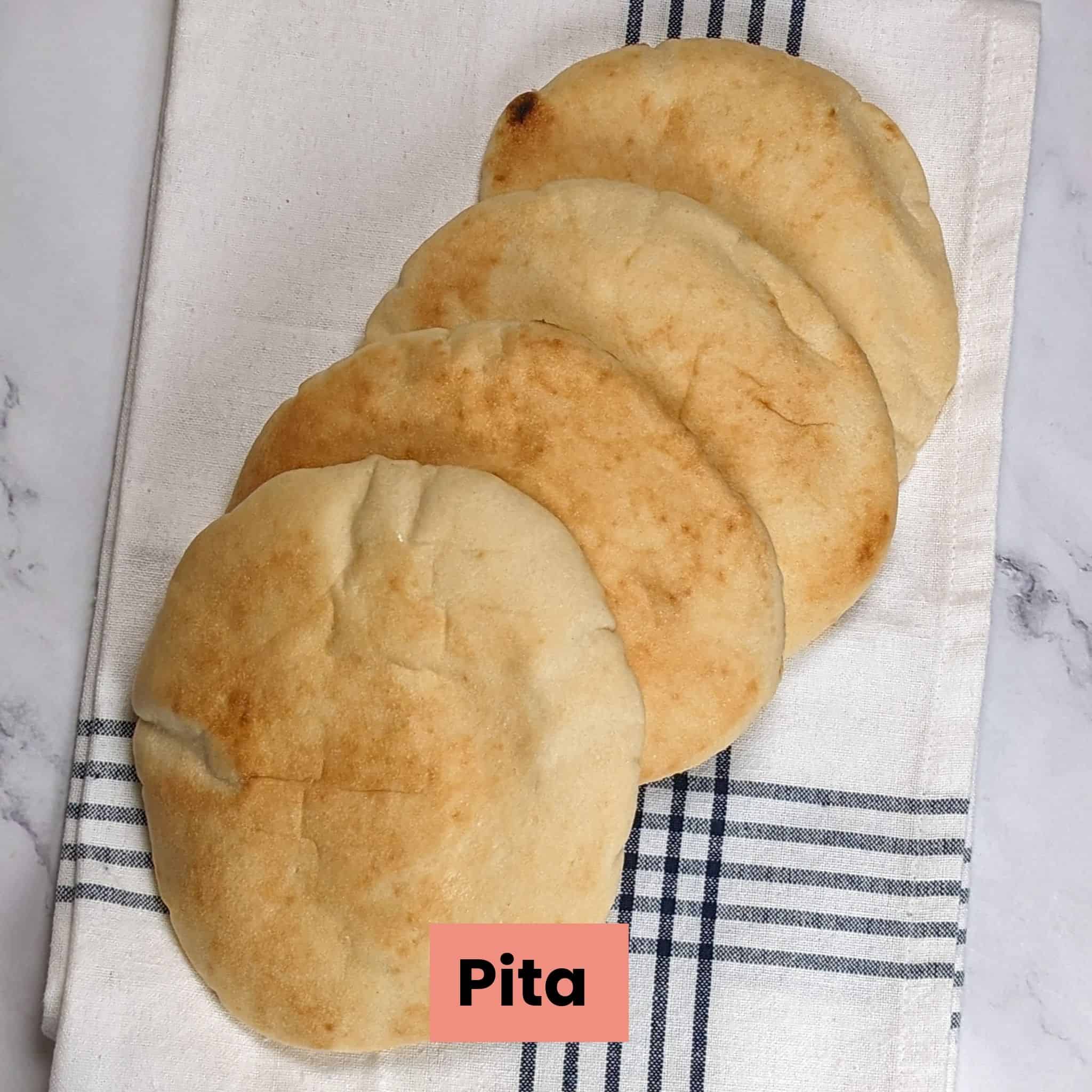 pitas cascading on top of a kitchen towel.