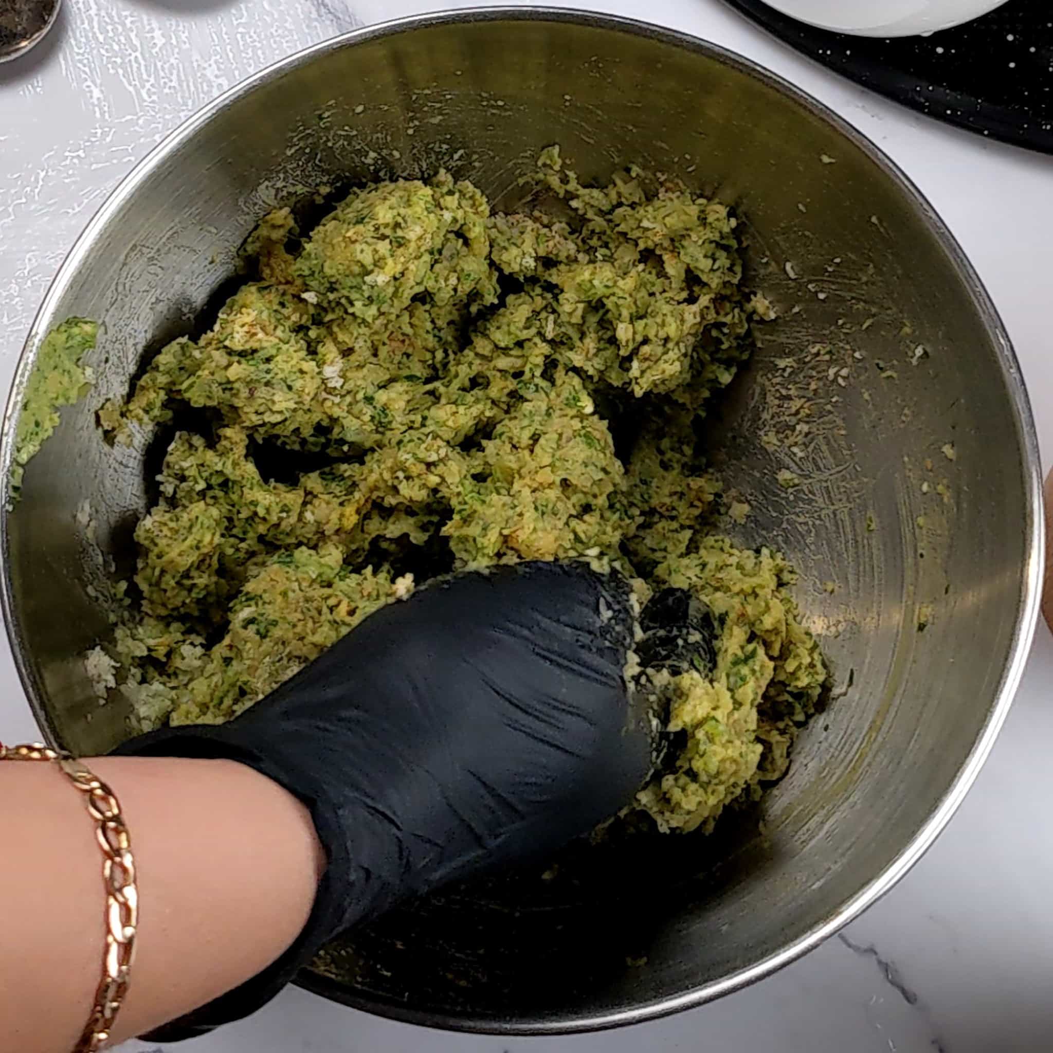 gloved hands mixing the falafel mixture.