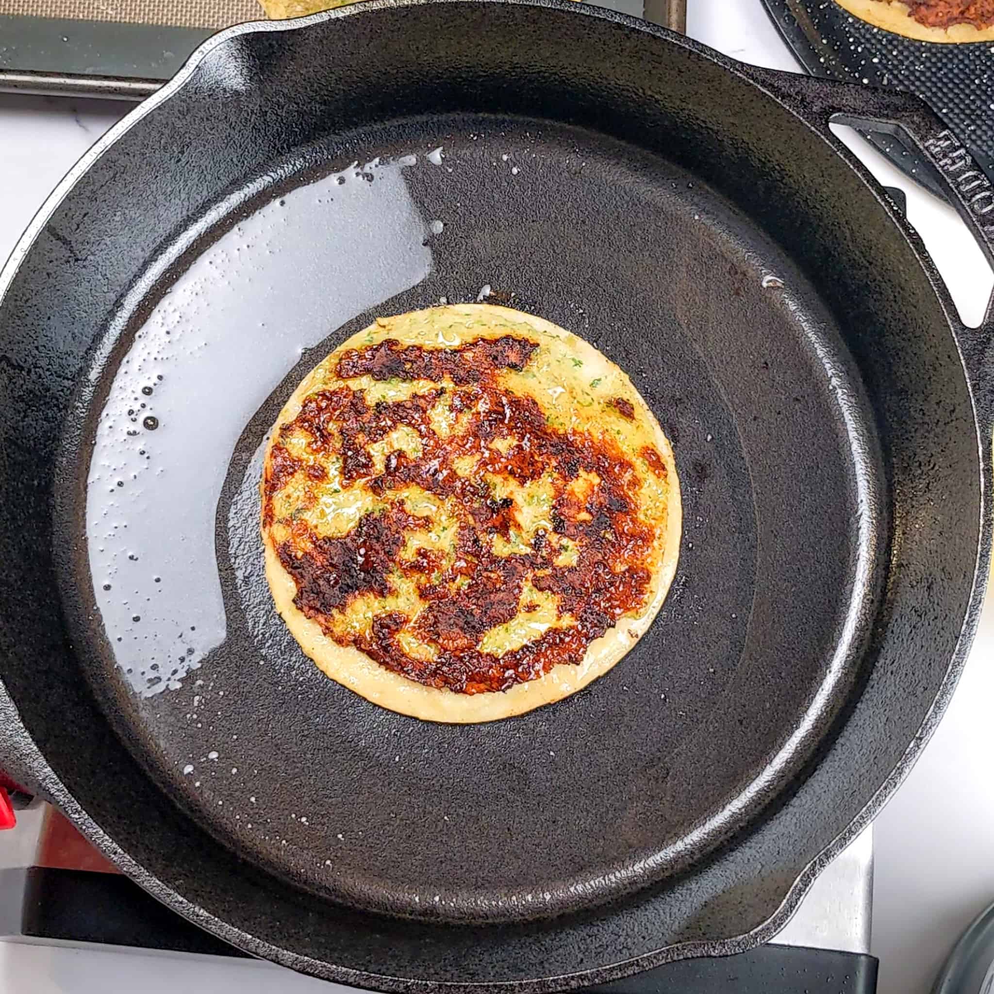 pan fried chicken taco with golden brown meat side up in a cast iron with olive oil.