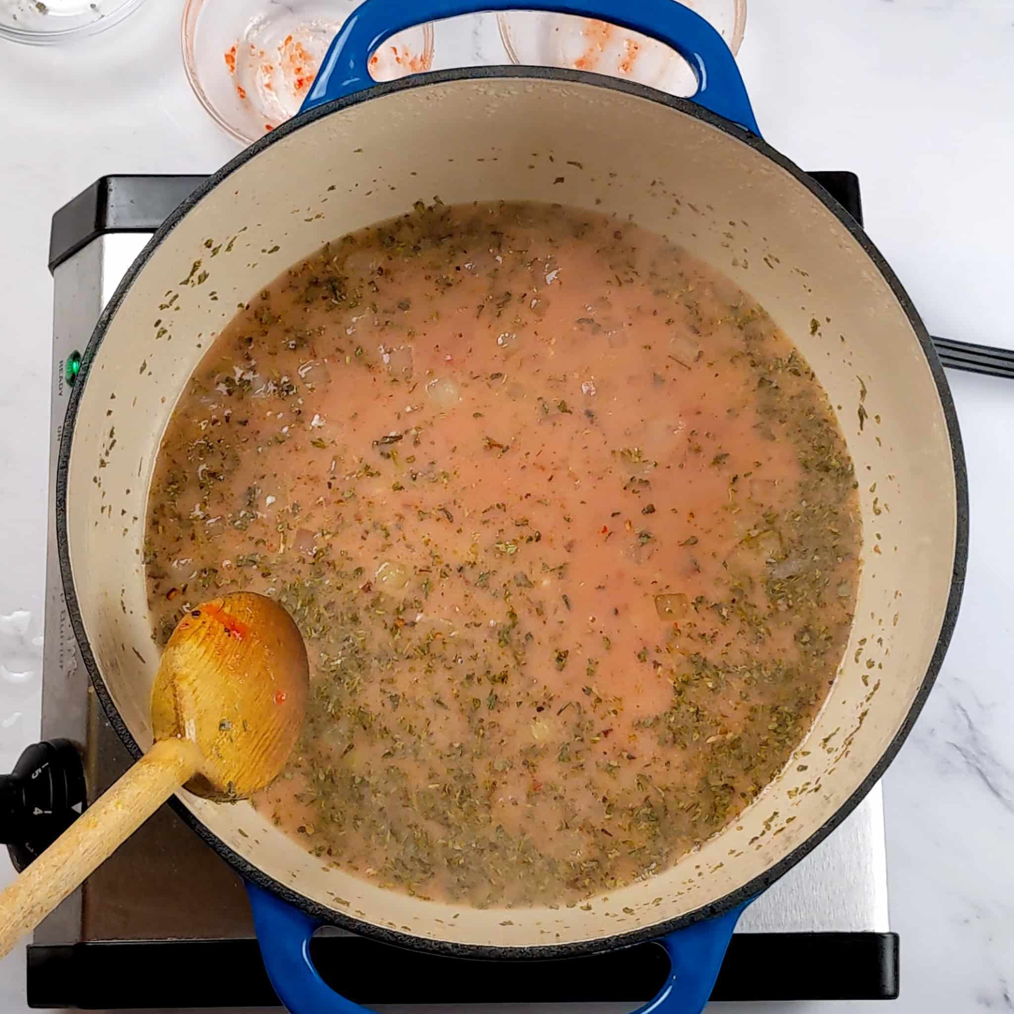 coconut milk with garlic chili sauce, fire roasted tomatoes and herbs in a dutch oven.