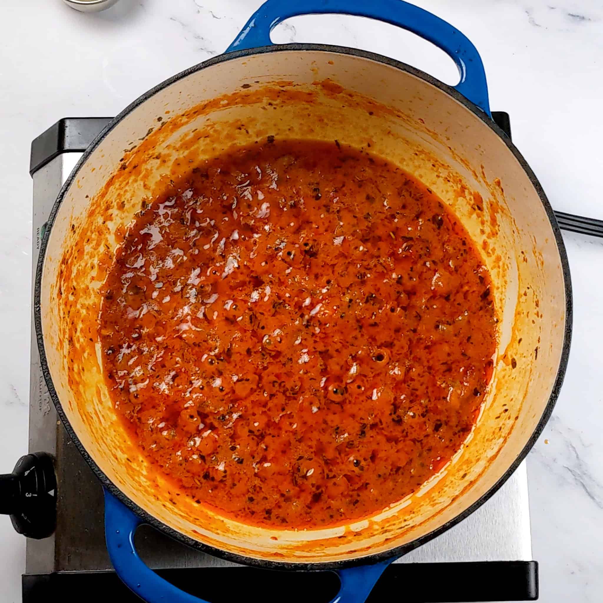 a reduced garlic chili sauce coconut curry in a dutch oven.