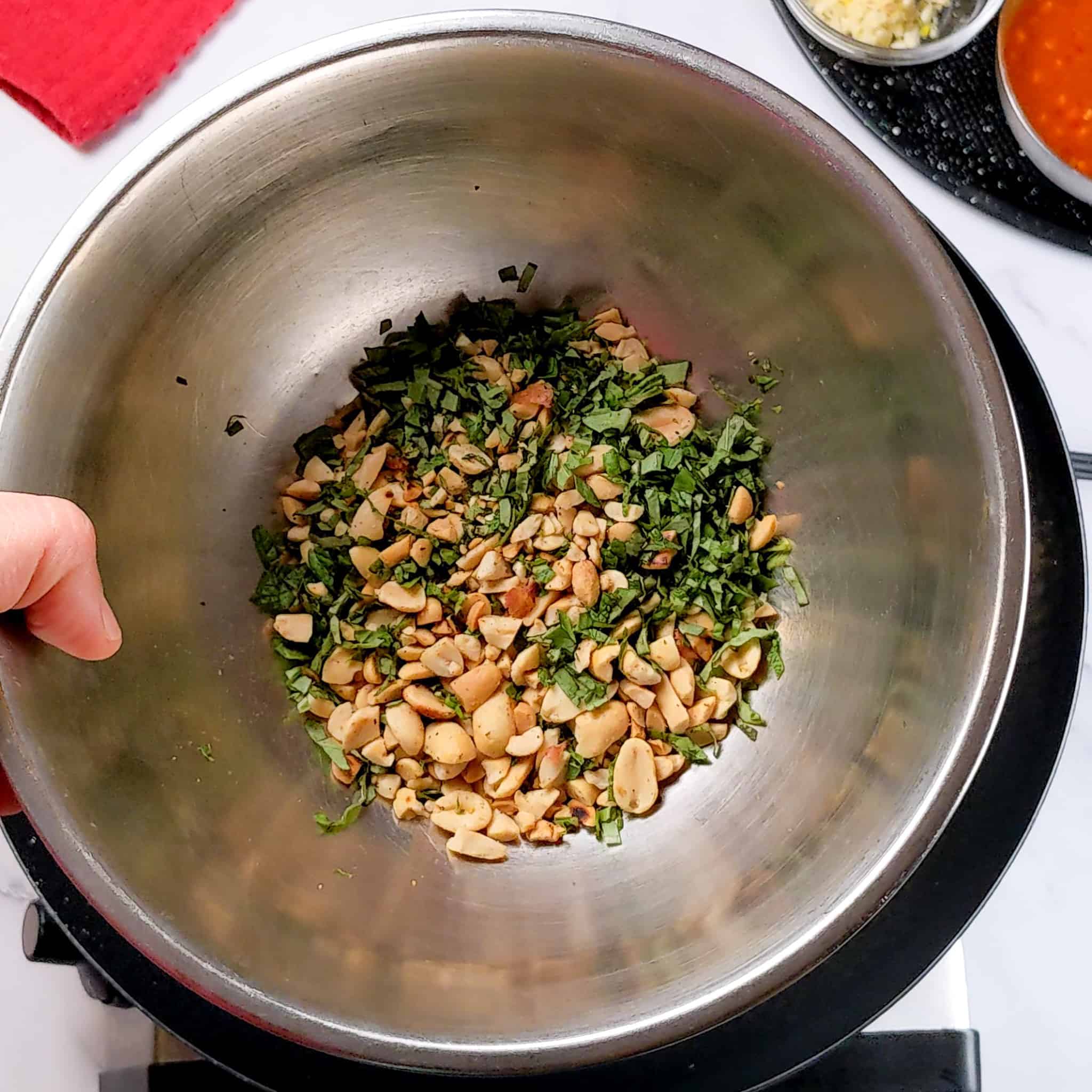 stainless mixing bowl with the toasted crushed peanuts tossed with the chopped fresh basil and mint.
