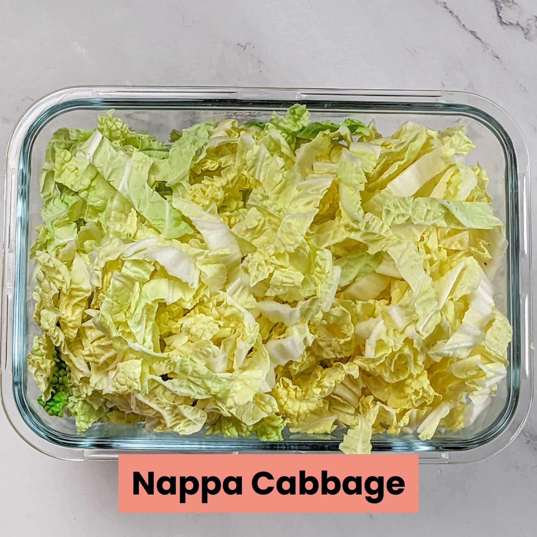 nappa cabbage strips in a deep rectangle glass container.