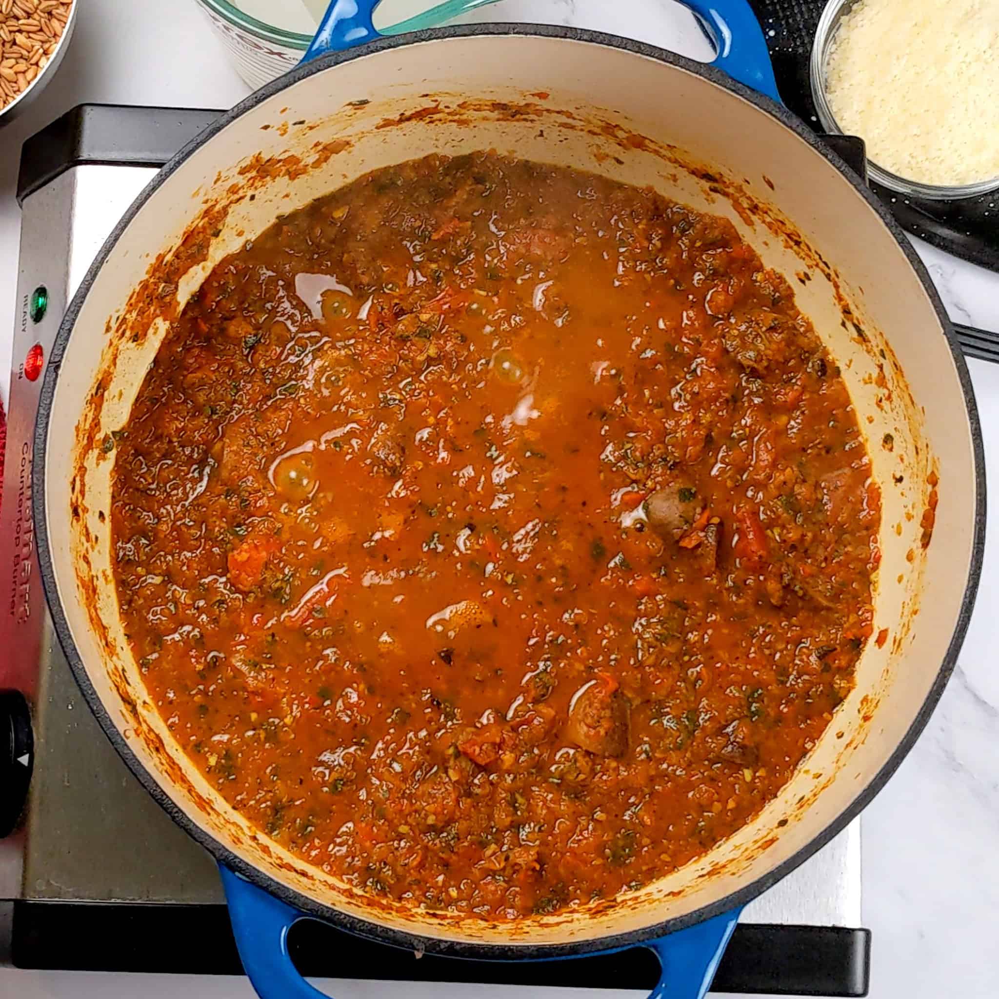 tomato red bell pepper aromatic paste with broth cooked down with tomatoes and mushrooms in a lodge dutch oven.