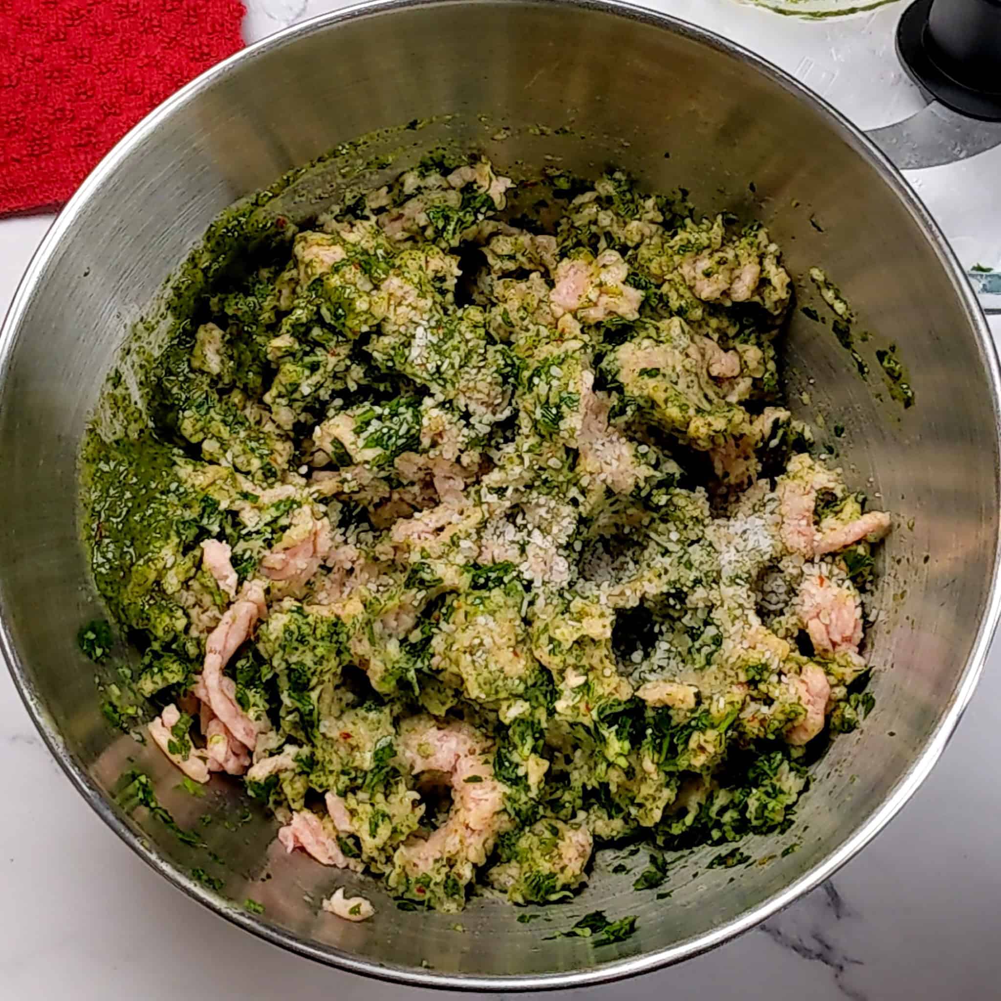 store bought ground chicken with zhug, and an aromatic paste of parsley, shallots and garlic in a stainless steel mixing bowl combined.