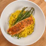 top view of the Best Air Fryer Habanero Adobo Salmon and Yellow Risotto with asparagus on a round wide rim bowl