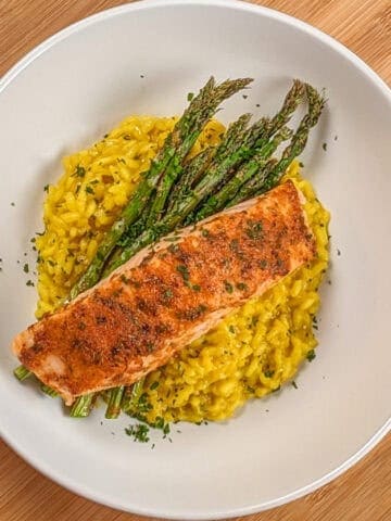 top view of the Best Air Fryer Habanero Adobo Salmon and Yellow Risotto with asparagus on a round wide rim bowl