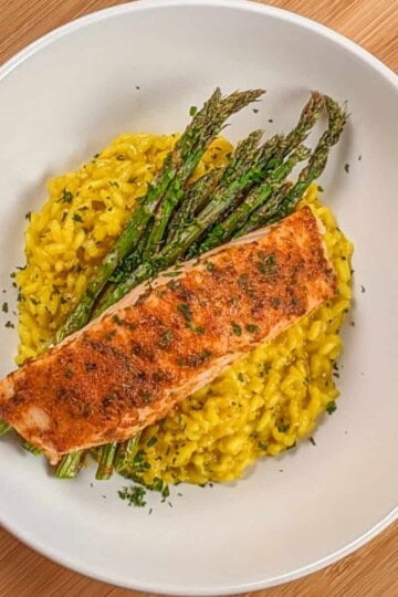 top view of the Best Air Fryer Habanero Adobo Salmon and Yellow Risotto with asparagus on a round wide rim bowl