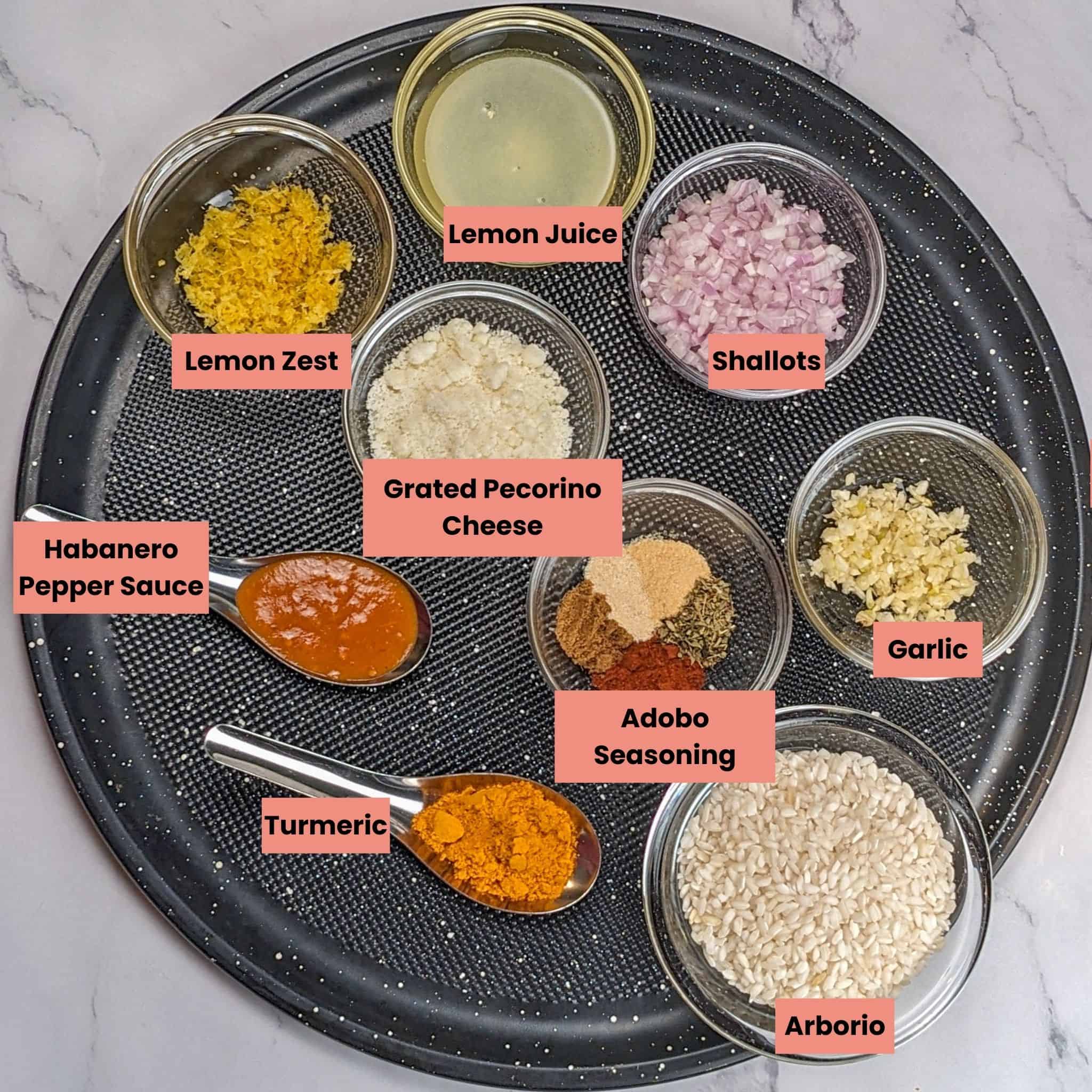 Ingredients for the Best Air Fryer Habanero Adobo Salmon and Yellow Risotto in glass and stainless steel containers and spoons on a round large pizza pan