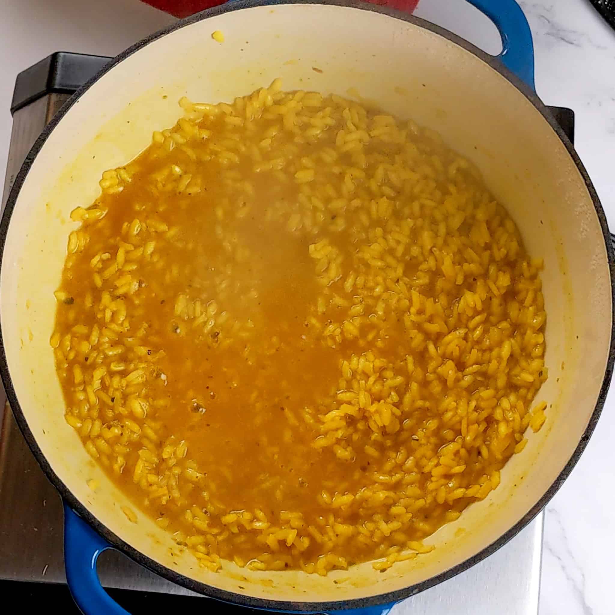 simmering yellow arborio rice in a dutch oven.