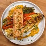 The Sheet Pan Citrus Chili Lime Salmon with Vegetables on a round flat plate with shallow sides.