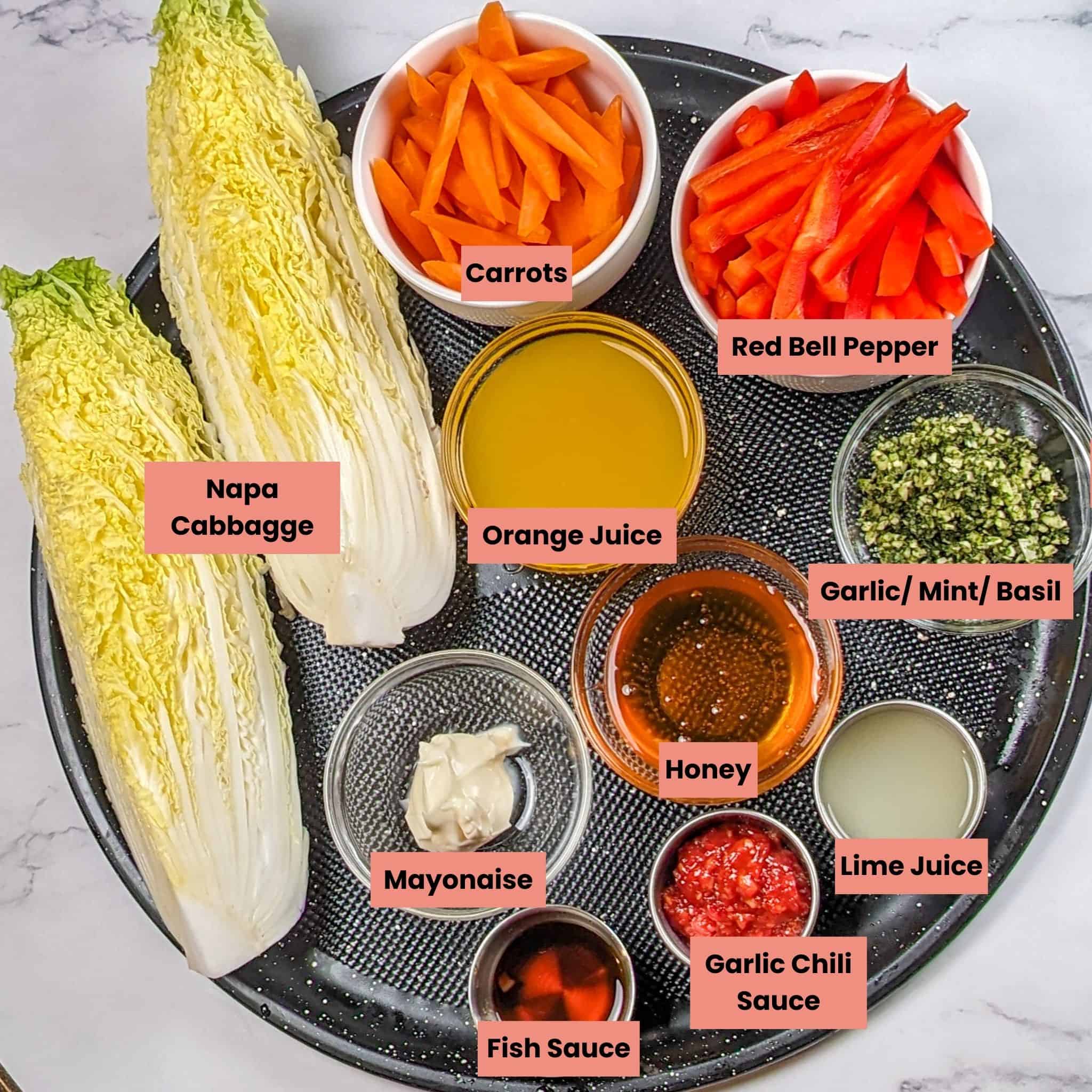 labeled Ingredients for the Sheet Pan Citrus Chili Lime Salmon with Vegetables on a large round pizza pan in glass and stainless steel containers.