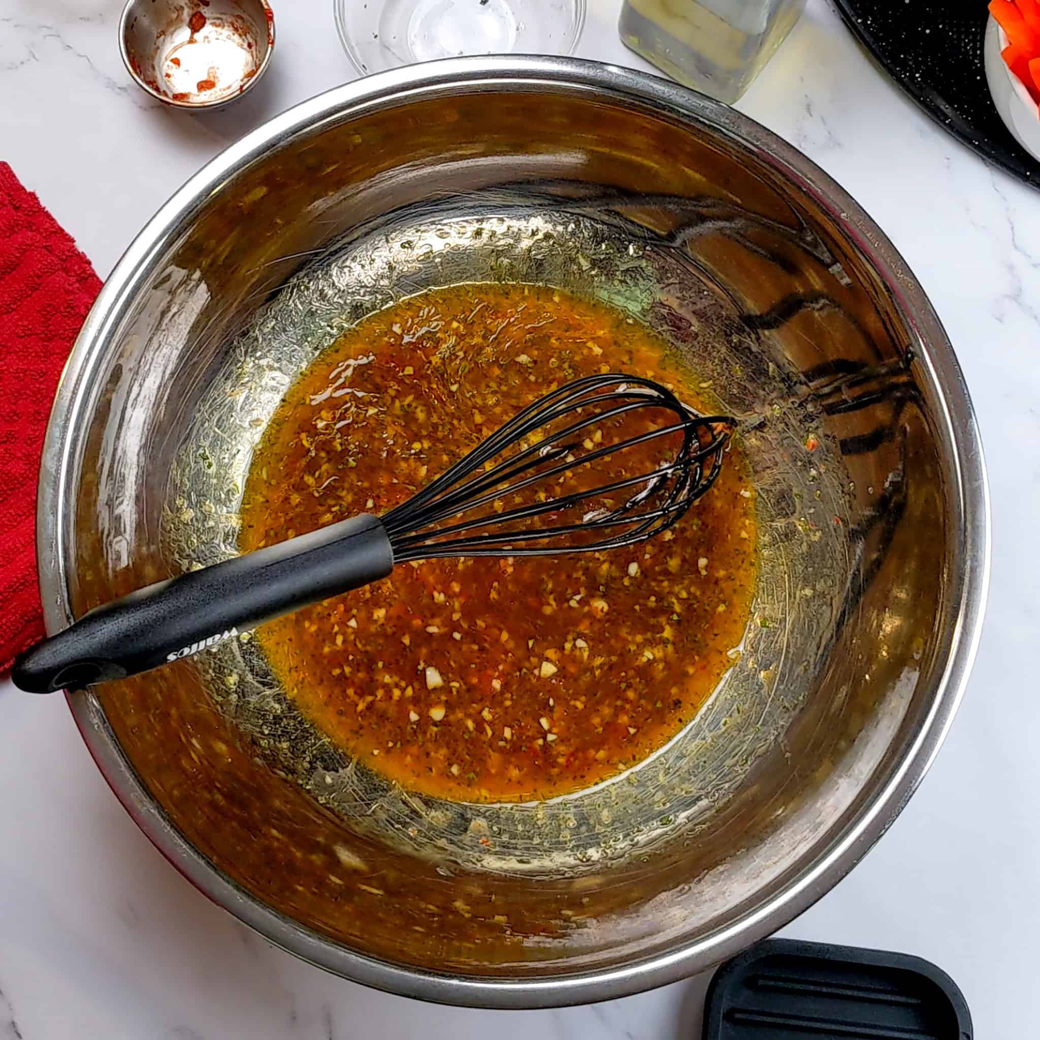 wet seasoning for the Chili Lime Salmon recipe in a large mixing bowl with a silicone whisk resting inside.