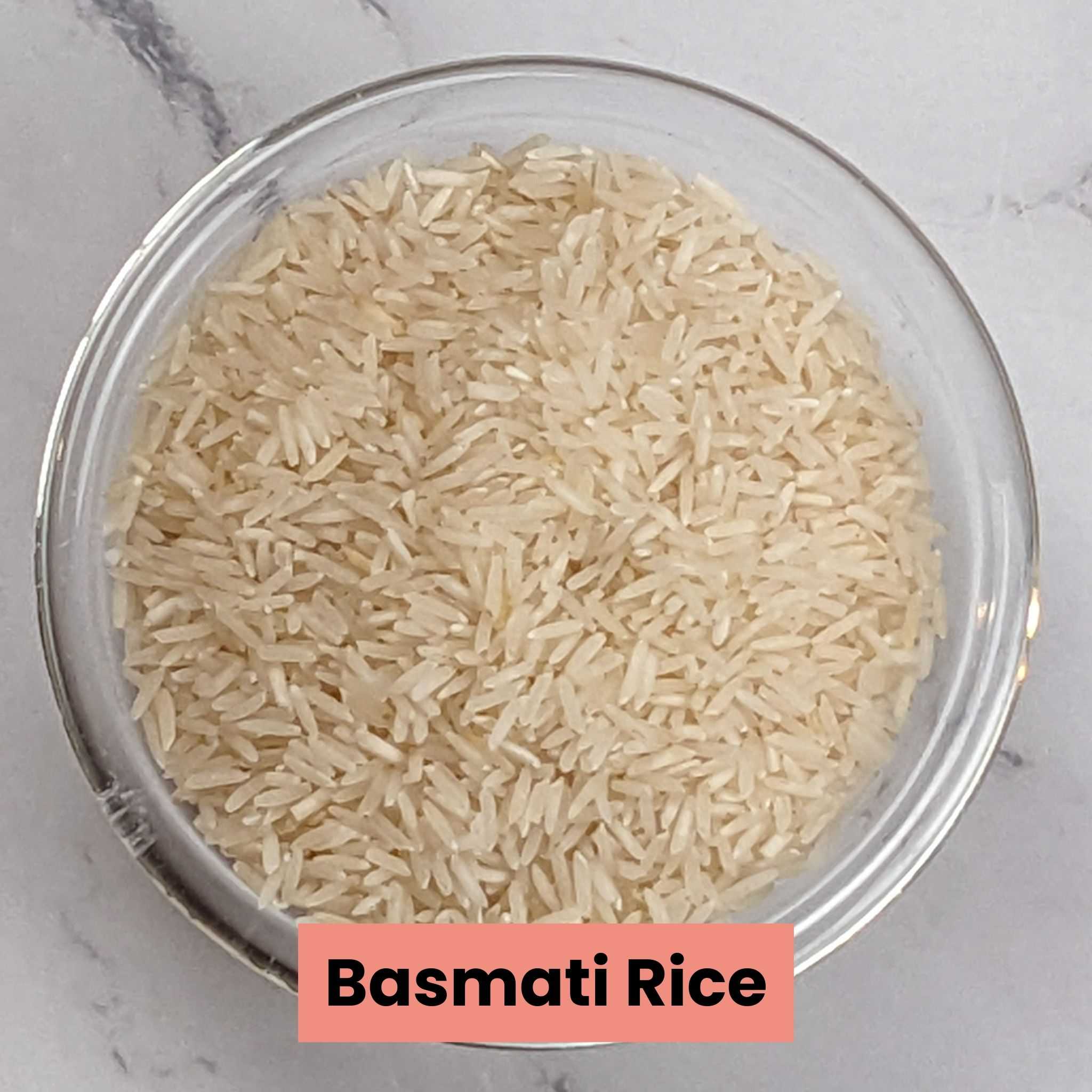 a closes up shot of raw basmati rice in a glass round dish.