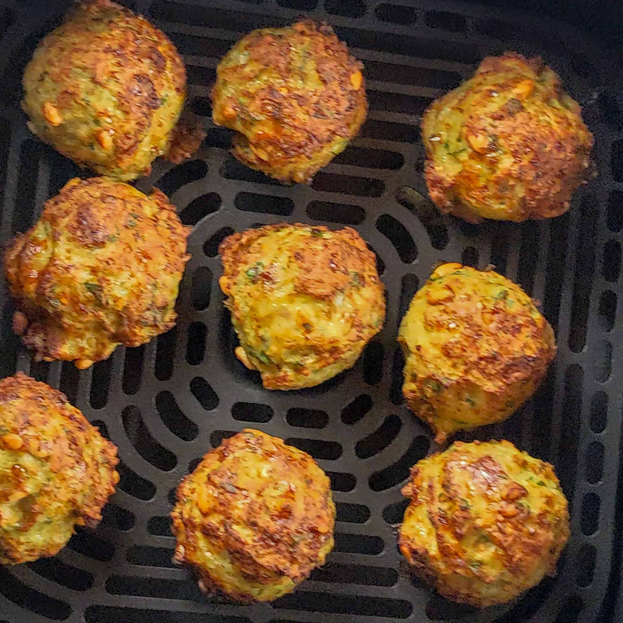 evenly spaced out golden brown cooked greek chicken meatballs.