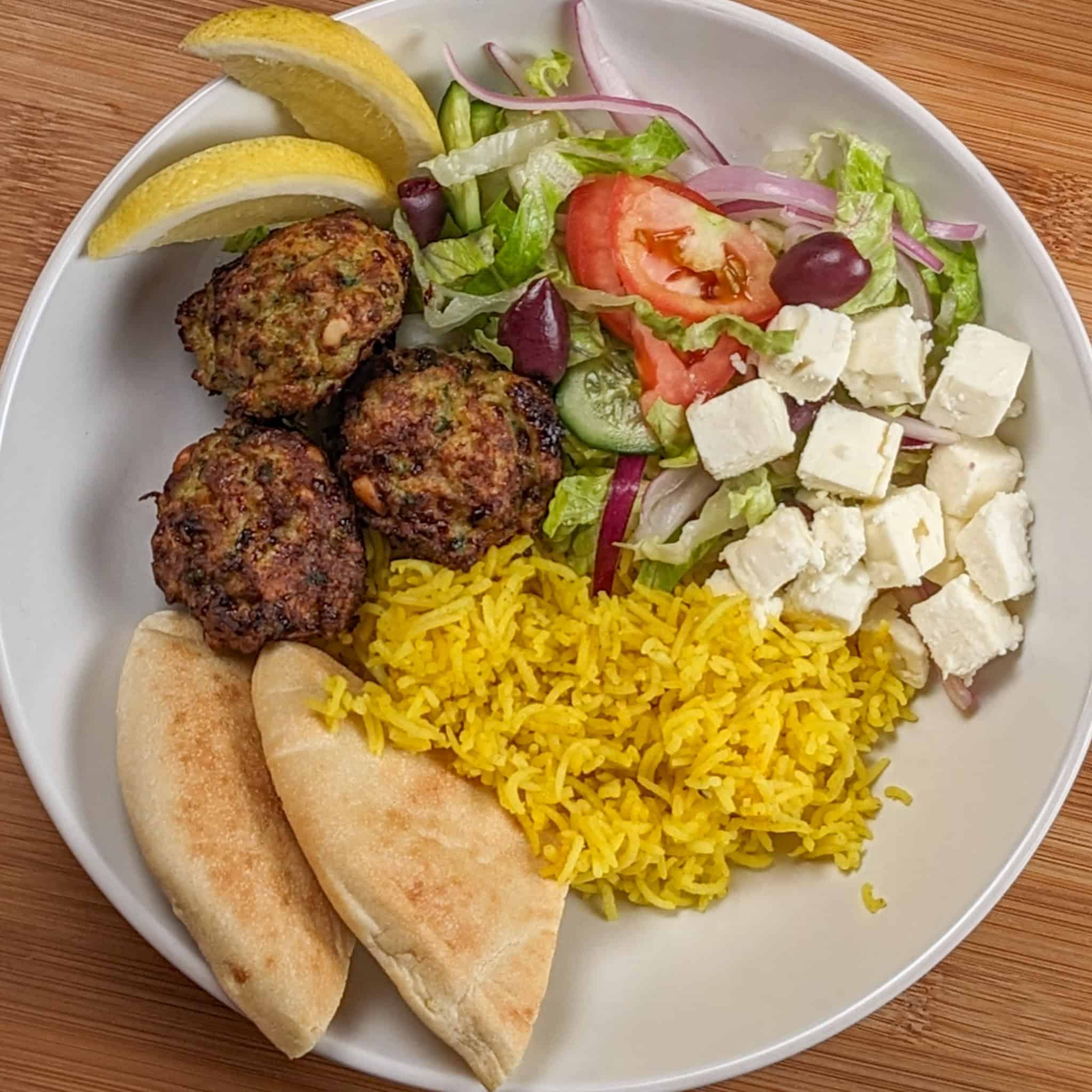 the Spicy Greek Chicken Meatball Rice Bowl in a wide rim bowl.