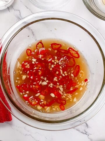 nouc cham sauce in a glass container.