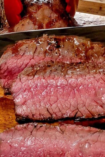pan-grilled flank steak being thinly sliced.