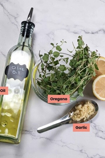 ingredients for the lemon oregano vinaigrette in spread out and labeled.