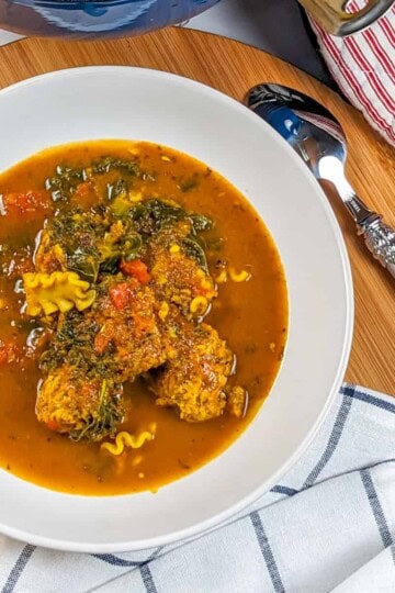 Vibrant curry turkey meatball soup with fresh vegetables and pasta, perfect for comfort.