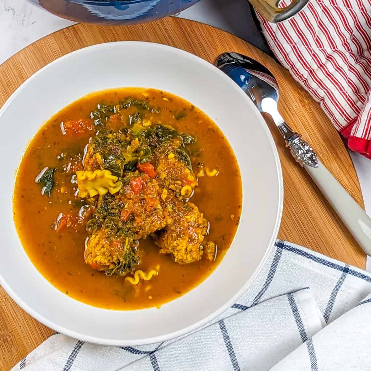 Vibrant curry turkey meatball soup with fresh vegetables and pasta, perfect for comfort.