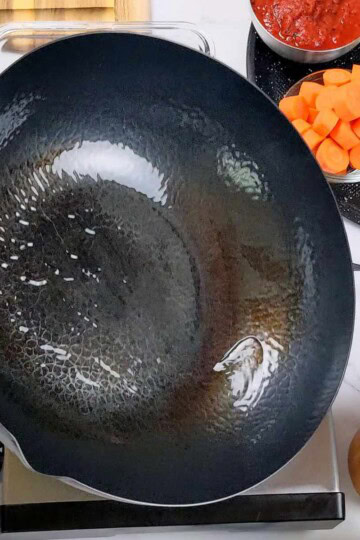 Fresh ingredients ready for cooking in a well-prepared kitchen with a cast iron pan being oiled.