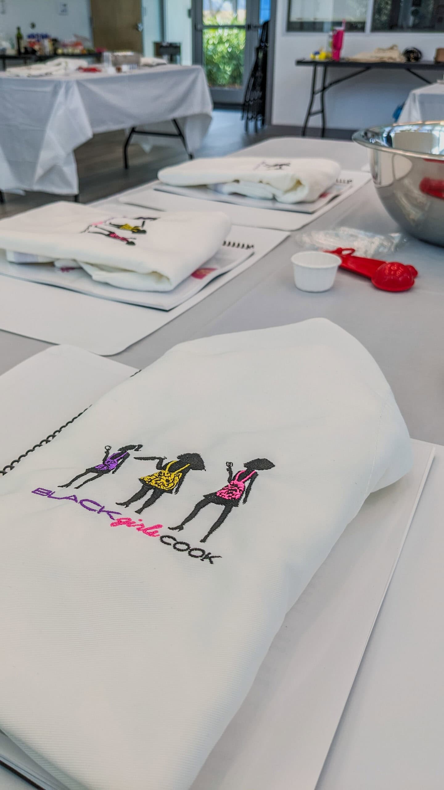 tables set up for the class with the black girls cook apron on top.
