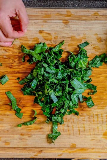 chopped collard greens on a cutting board.