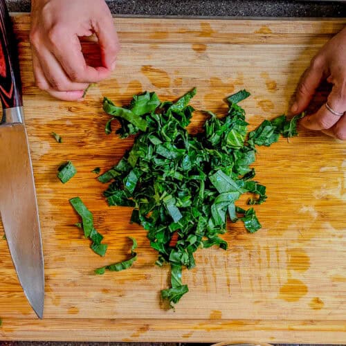 chopped collard greens on a cutting board.