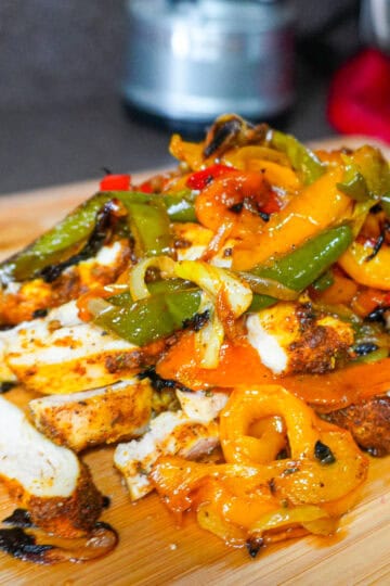 oven-roasted jerk chicken fajitas piled up on a cutting board.