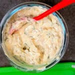 cholula green chli sour cream in a glass bowl with a spoon.