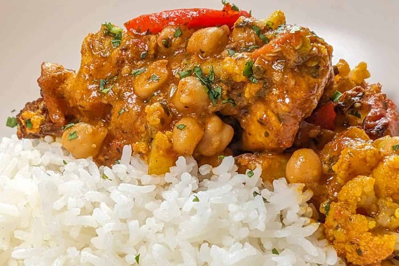 side view of the Air Fryer Roasted Chicken Chickpeas Vegetable Curry recipe in a wide rim bowl with basmati rice.