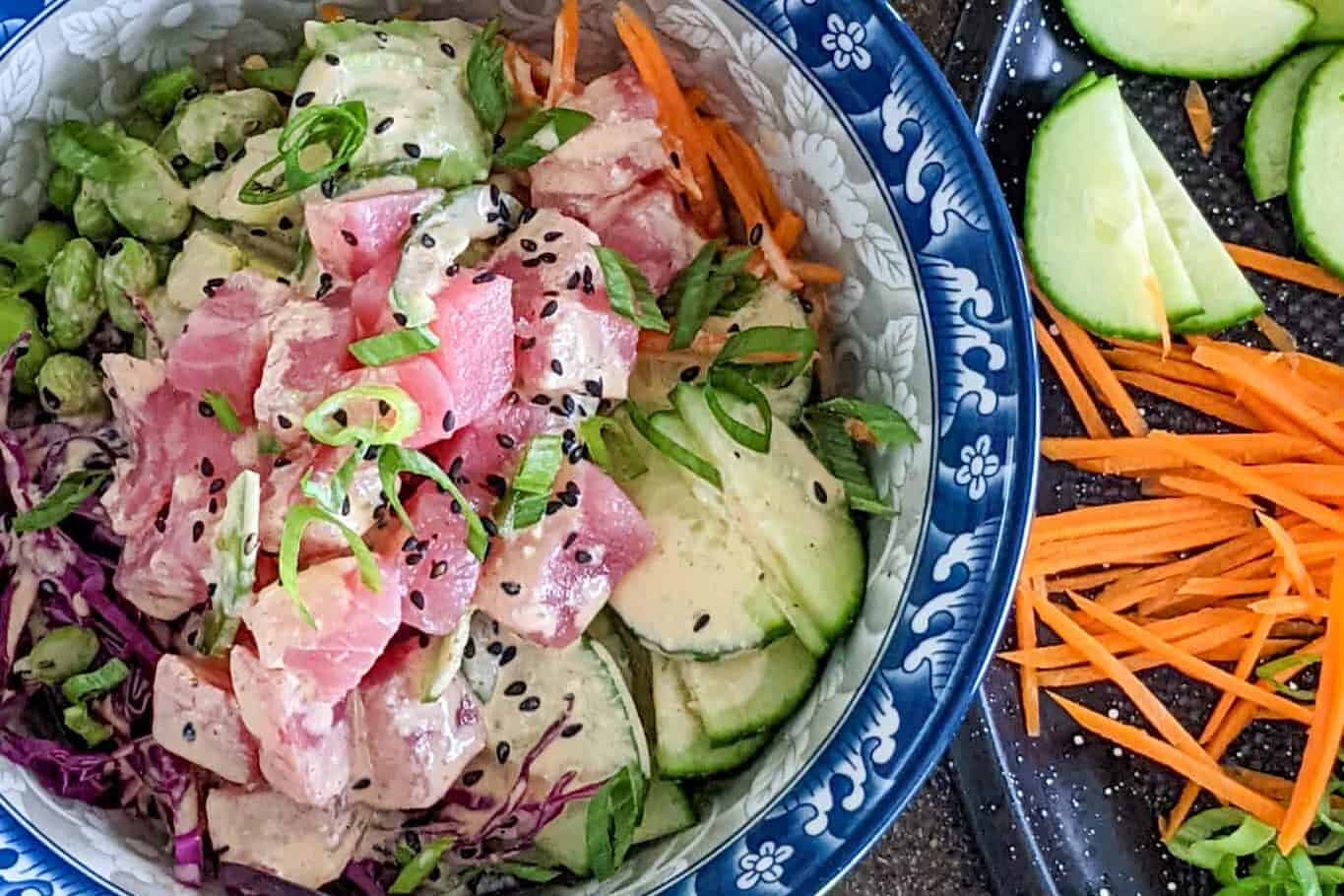 sesame tuna rice bowl in a bowl surrounded by the ingredients.